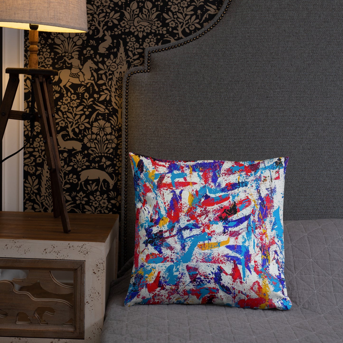Throw pillow featuring a colorful abstract design, displayed on a neutral bed for a bold modern accent
