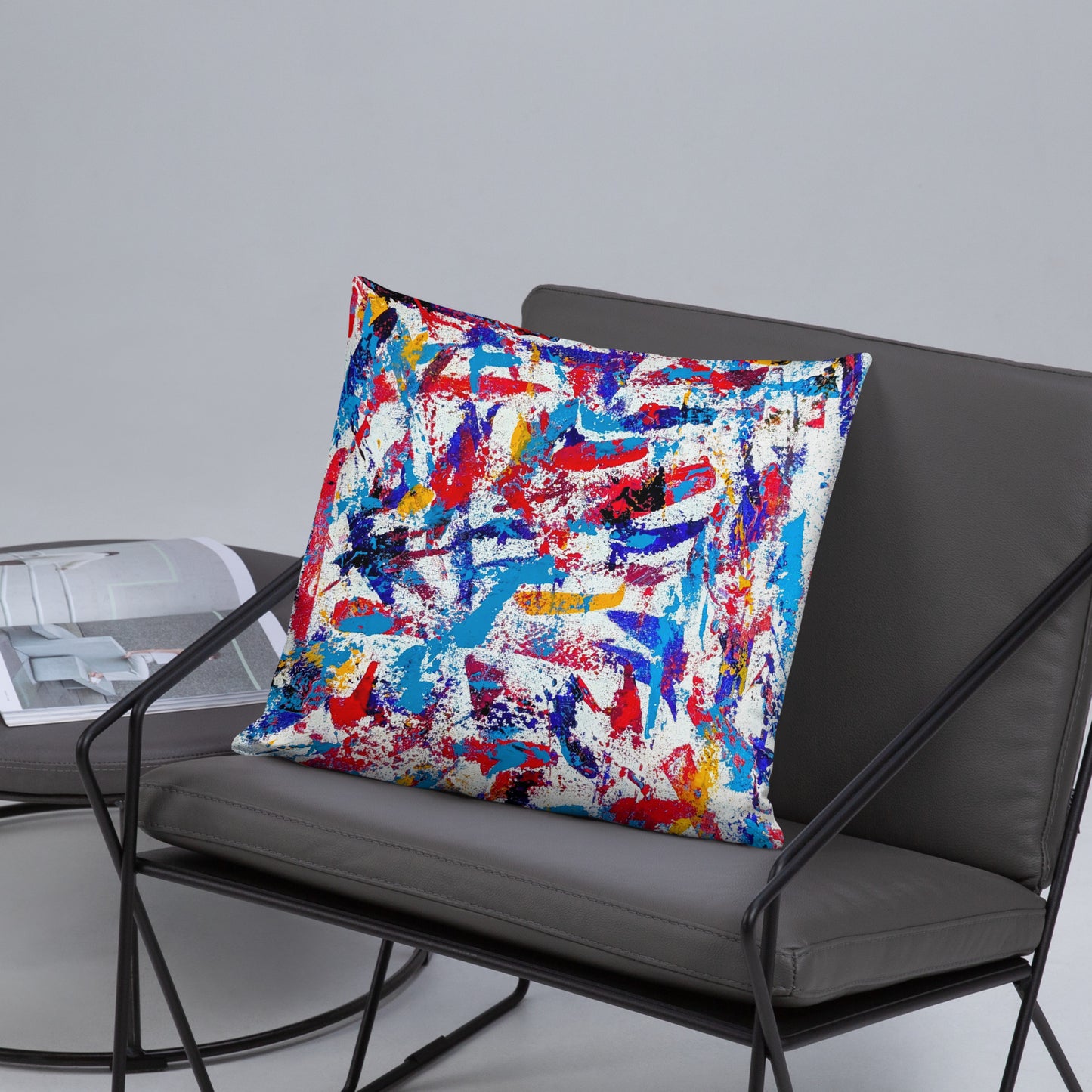 Throw pillow featuring a colorful abstract design, displayed on a neutral chair for a bold modern accent