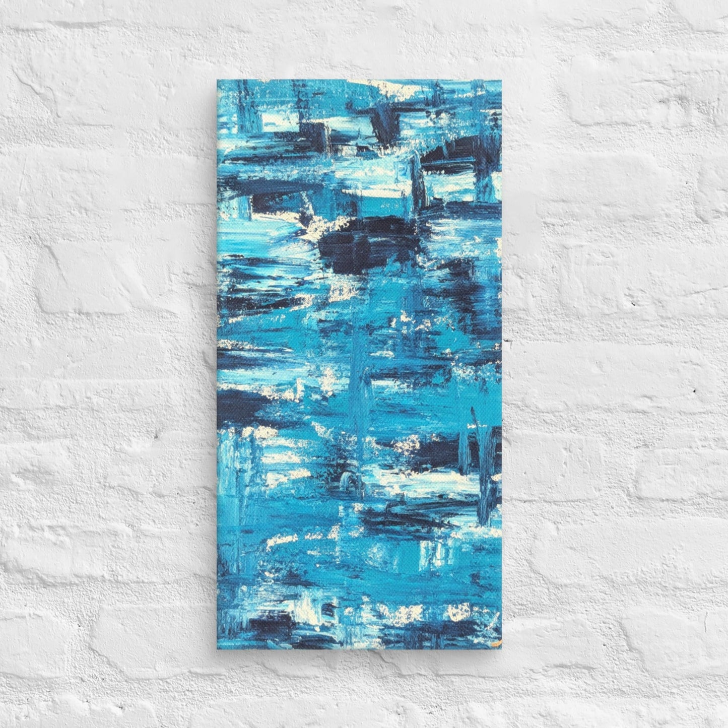 Canvas print of the abstract painting "Blue Streak" with layered blue and white brushstrokes, displayed on a white brick wall in a minimalist interior setting.