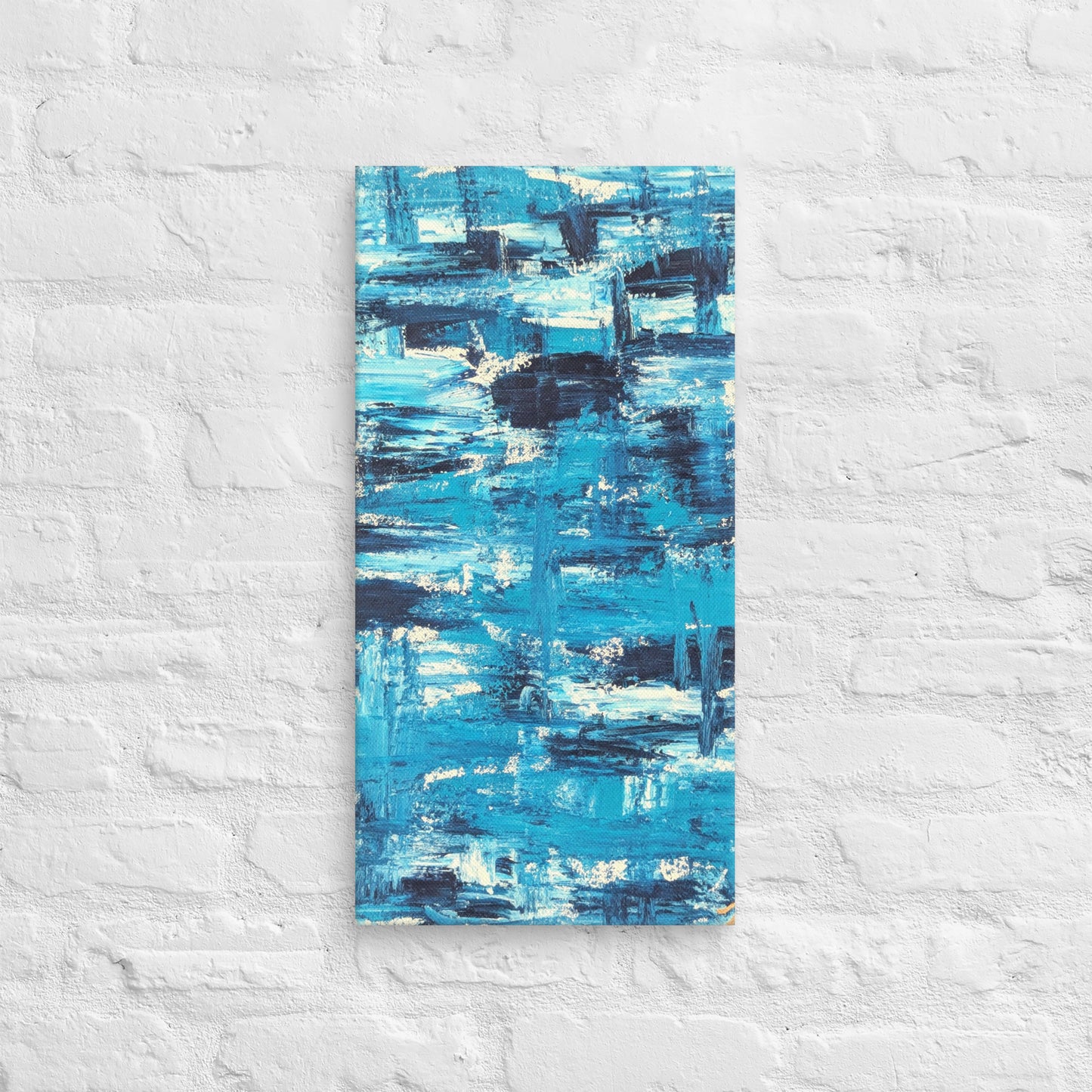 Canvas print of the abstract painting "Blue Streak" with layered blue and white brushstrokes, displayed on a white brick wall in a minimalist interior setting.