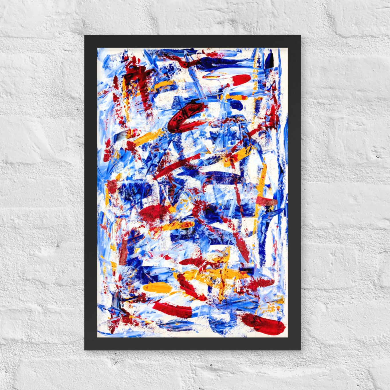 Framed abstract print titled "Rebel Parade" featuring bold red, blue, and white brushstrokes, displayed on a white brick wall in a modern interior setting.