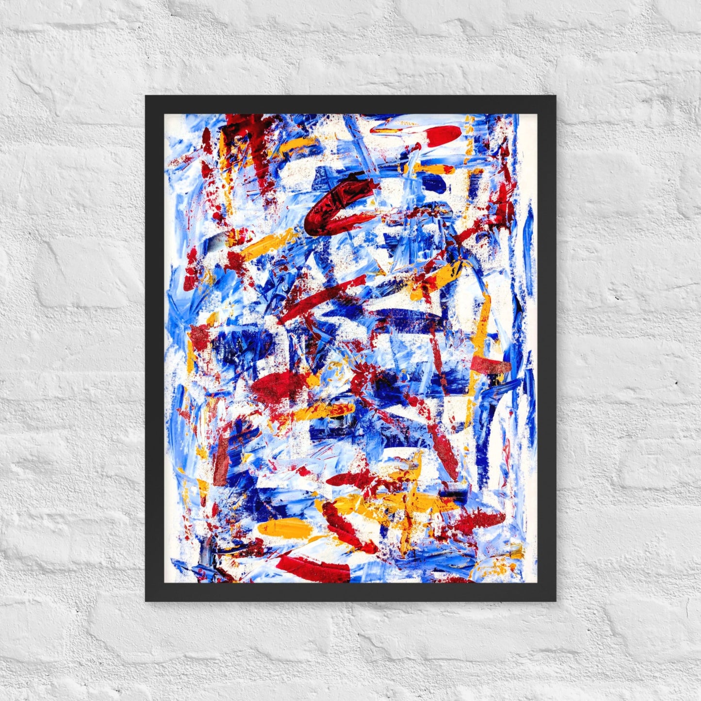 Framed abstract print titled "Rebel Parade" featuring bold red, blue, and white brushstrokes, displayed on a white brick wall in a modern interior setting.