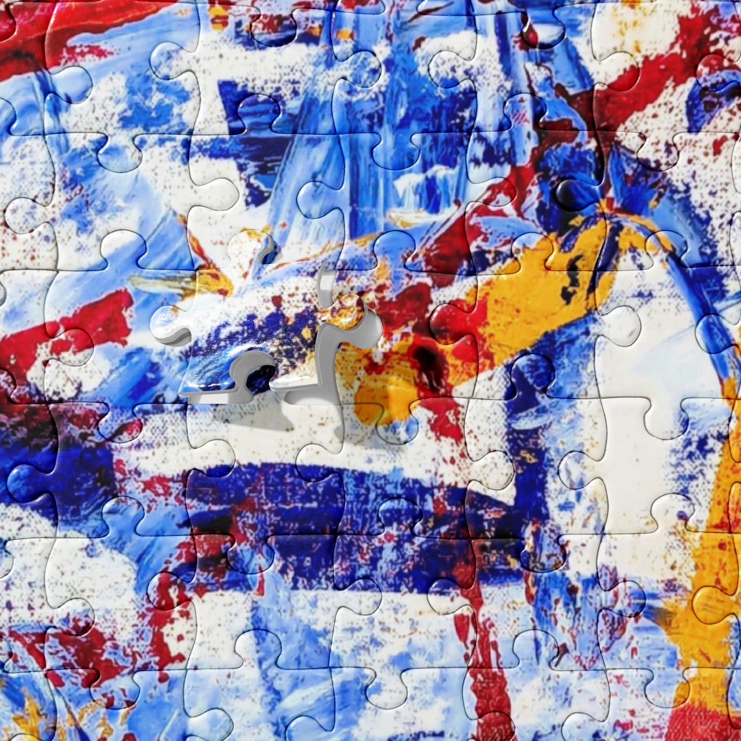 520-piece jigsaw puzzle featuring the abstract artwork "Rebel Parade" up close with bold red, blue, and white brushstrokes, partially assembled on a flat surface.